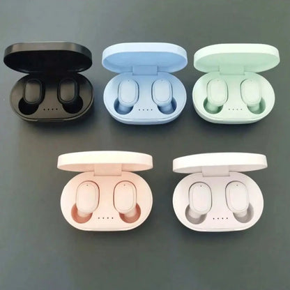 Five pairs of wireless earbuds in open cases on a gray background